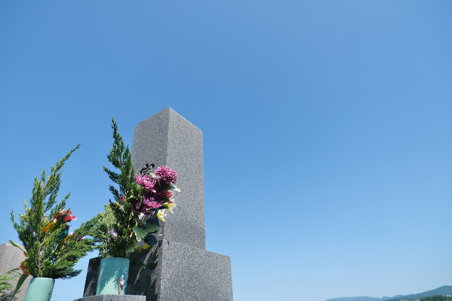 青空の下のお墓と供花